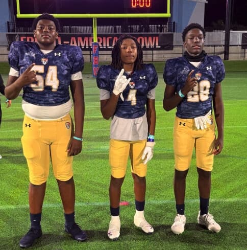 Urijah Springs, number 4, between Landrey Thompson and a teammate on the field at the FBU All-American Bowl